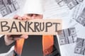 A builder holding a bankrupt signboard