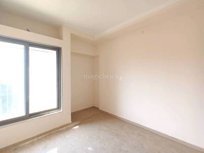 Spacious room with large window, light-colored walls, and durable concrete flooring, offering a blank canvas for customization. in Rustomjee Athena