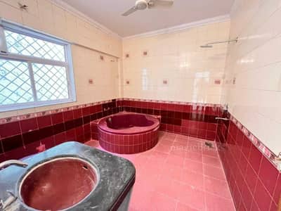 The bathroom has red and white tiles, a bathtub, and a washbasin